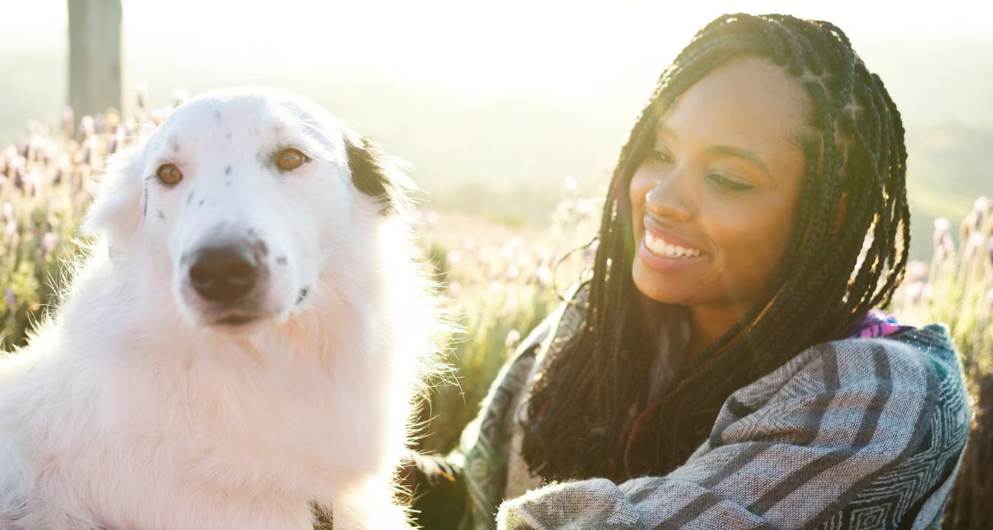 woman-and-a-beautiful-dog-sitting-on-the-floor-in-a-flower-field-picture-id1161599203-ezgif.com-avif-to-jpg-converter